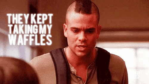 a man with a mohawk and a backpack is talking to a woman and they kept taking my waffles .
