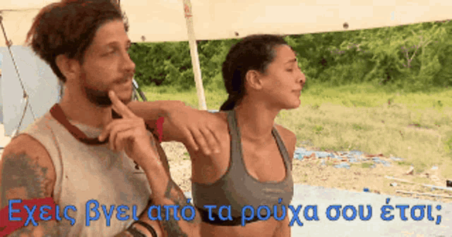 a man and a woman are standing next to each other with the words exies byeano ta rouxa sou etou in blue letters