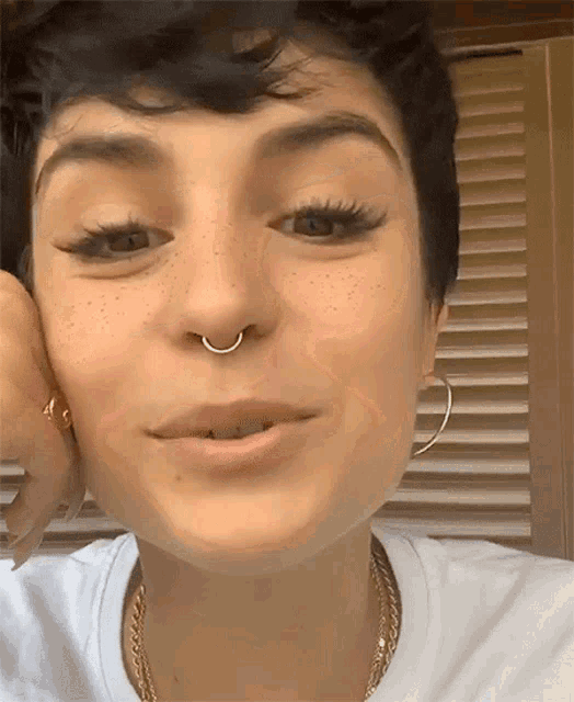 a woman with a nose ring and hoop earrings