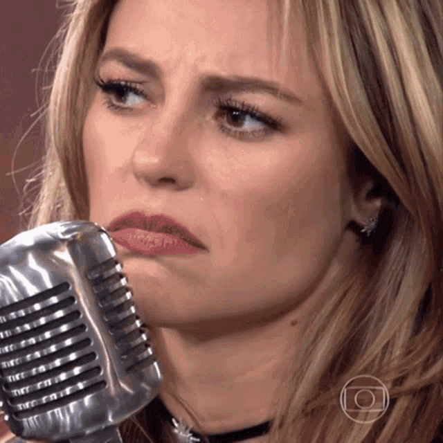 a close up of a woman 's face with a microphone in front of her