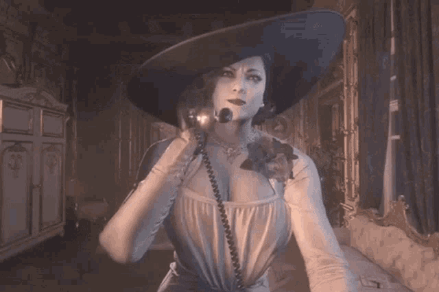a woman in a large hat and dress is standing in a dark room .