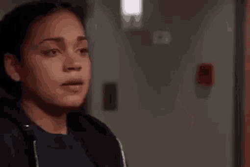 a close up of a woman covering her mouth with her hand in a room .