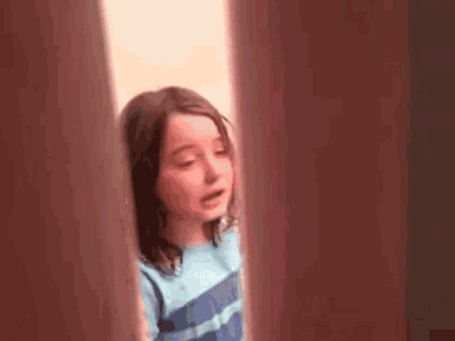 a little girl is crying while standing in a room .