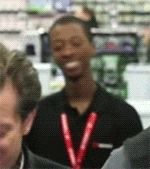 a man with a red lanyard around his neck is smiling