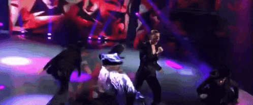 a group of people are dancing on a stage in a club .
