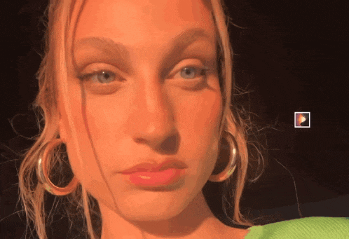 a close up of a woman 's face with a play button in the background