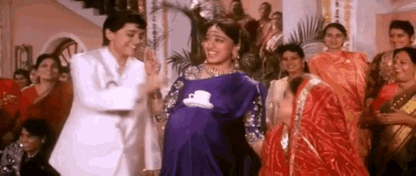 a man and a woman are dancing in a room with a group of women .