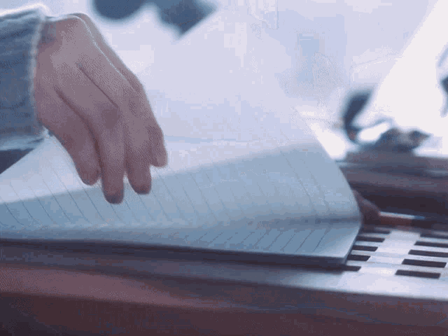 a close up of a person 's hand on a notebook