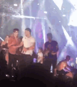 a blurry picture of people dancing on a stage at a concert