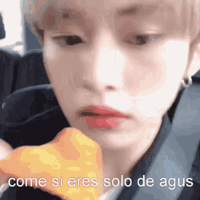 a close up of a person eating a slice of pizza with the words come si eres solo de agus written on the bottom