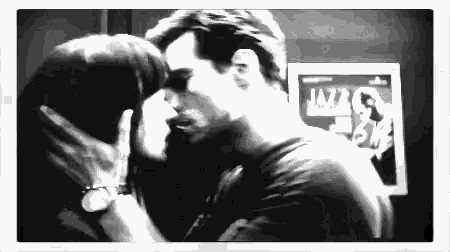 a man and woman are kissing in front of a jazz poster