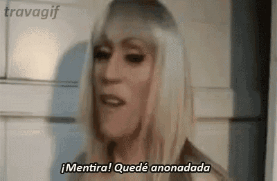 a woman with blonde hair is making a funny face and says `` mentira ! quede anonada '' .