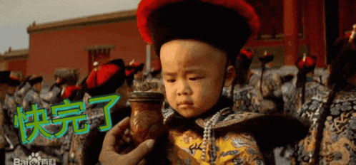 a baby in a costume is holding a container with chinese characters on it