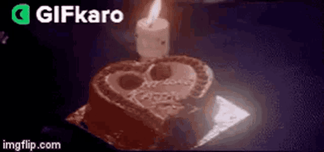 a heart shaped birthday cake with a lit candle on it .