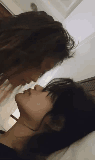 a close up of two people 's faces kissing