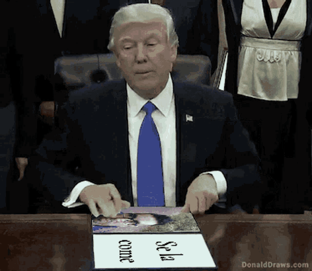 donald trump is sitting at a desk with a sign that says sea come