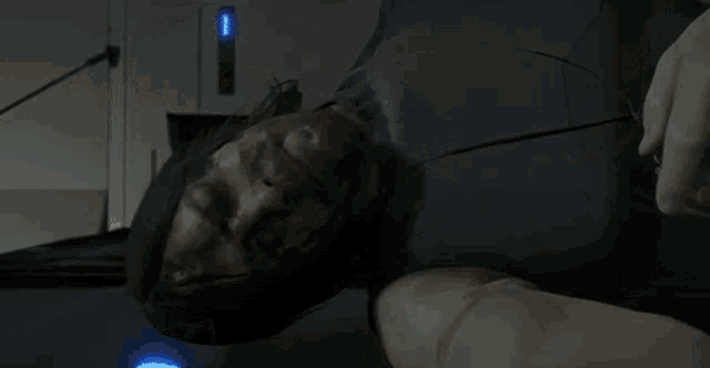 a man with a beard is laying on a bed with a remote control on his wrist .