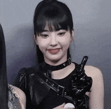 a woman is wearing a choker and holding a knife and giving the middle finger .