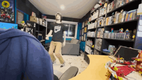 a man is dancing in a room with a lot of books on shelves