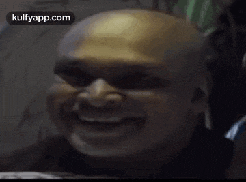 a close up of a bald man 's face with the words kulfyapp.com written below it