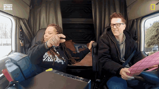 a man and a woman sitting in a truck with breaking bobby bones written on the bottom