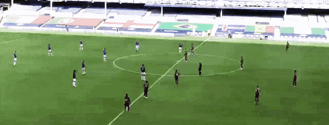 a group of soccer players are playing on a field with a stadium in the background that has a flag that says brazil on it