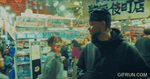 a man and woman are standing in a store with a sign that says gifrun.com on it