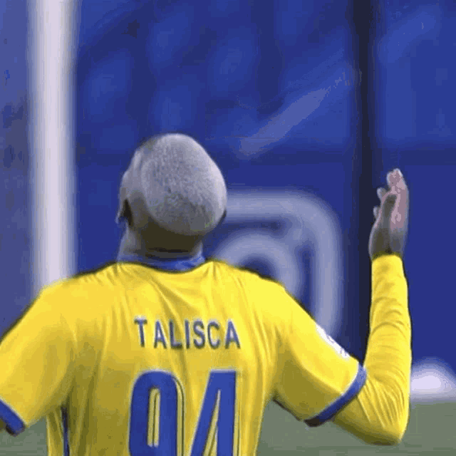 a soccer player wearing a yellow jersey with the name talisac on the back