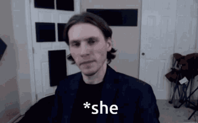 a man in a suit says * she * in front of a door