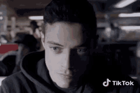 a close up of a man 's face with a tiktok logo in the background