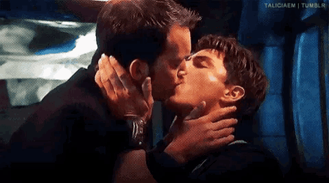 two men are kissing each other in a room .