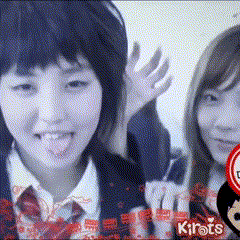 two girls are standing next to each other and one is waving her hand