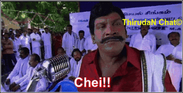 a man with a mustache stands in front of a microphone and says chei !