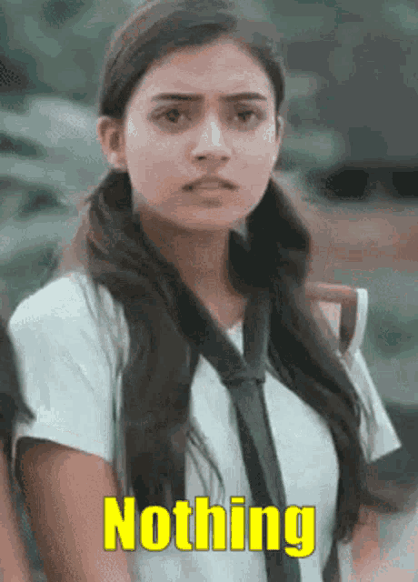 a girl in a school uniform and tie is standing next to a sign that says nothing .
