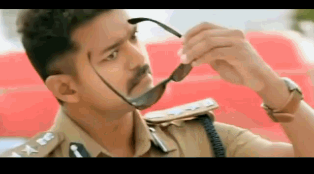 a man in a police uniform is wearing sunglasses .