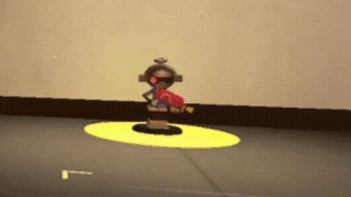 a toy robot is standing in a yellow circle on a black floor