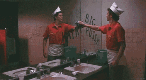 a man in a red shirt is cleaning a wall that says big