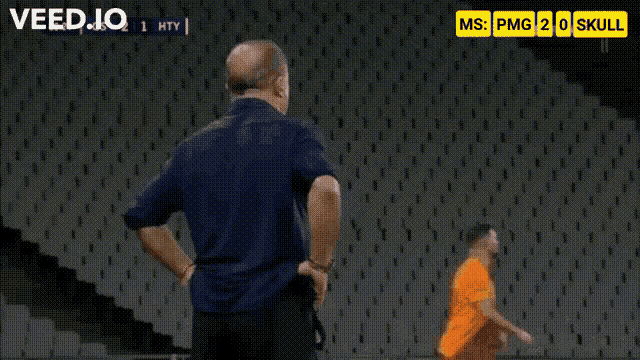 a man in a blue shirt is running in front of a screen that says ' veed.io ' on it