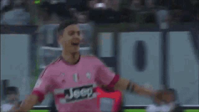 a man in a pink shirt with the word beer on it is standing in front of a crowd .