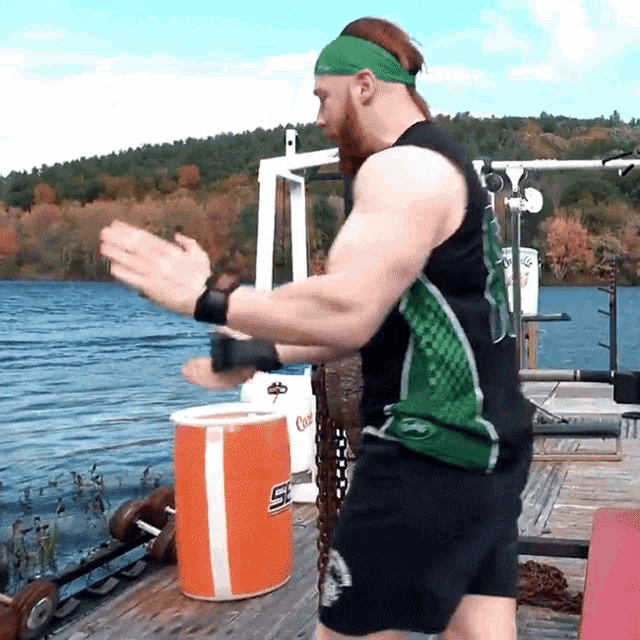 a man wearing a green headband stands in front of a gatorade cooler