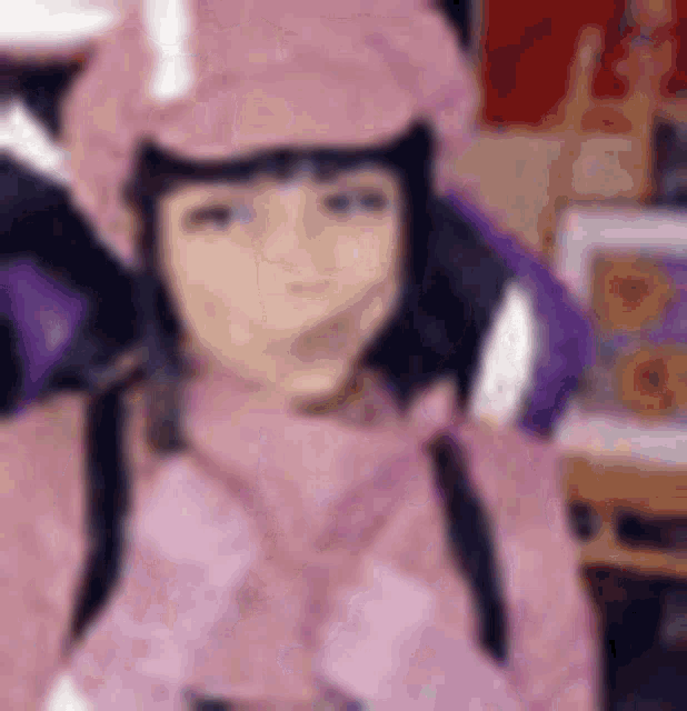 a blurry picture of a girl wearing a pink hat .