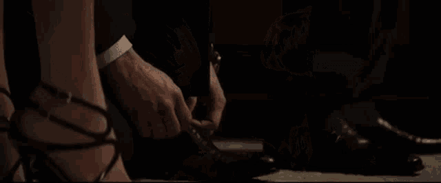 a man and a woman are standing next to each other in a dark room looking at something .
