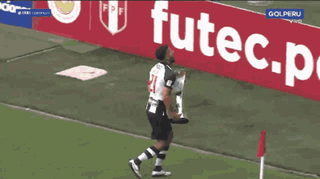a man holding a trophy that says gol peru on the bottom