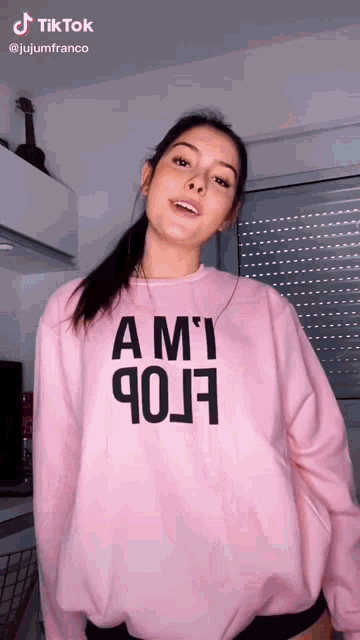 a woman is wearing a pink sweatshirt that says ami 90j7