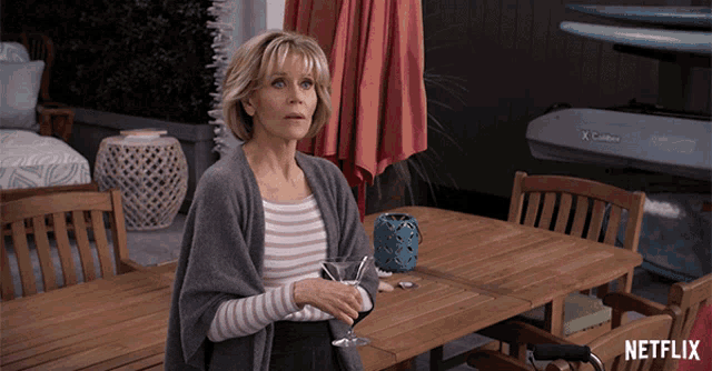 a woman is standing in front of a table with a netflix logo on it