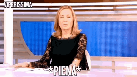 a woman is sitting at a desk with the words viperissima written above her