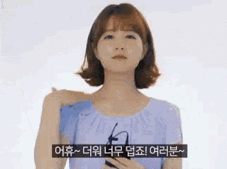 a woman in a blue dress is holding a cell phone in her hand .