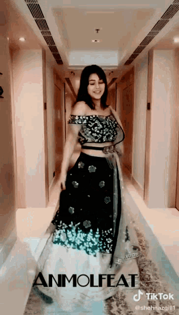 a woman in a black and white dress is standing in a hallway with the word tiktok on the bottom