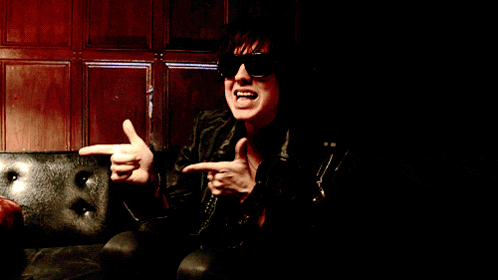 a man wearing sunglasses is sitting on a black couch