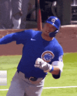 a baseball player wearing a chicago cubs uniform is swinging a bat